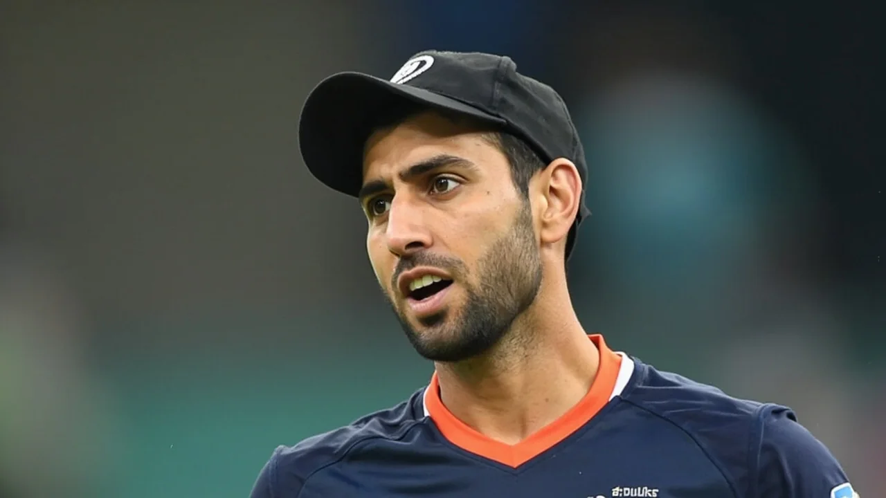 Medium tactical shot of a coach conferring with the captain at the end of an over, with the batting team resetting between overs and the fielding captain walking back to his mark
