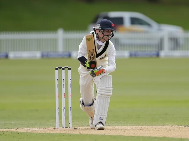 Wicketkeeper crouched behind stumps with gloves ready