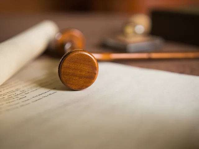 Legal document scroll and wooden gavel on desk
